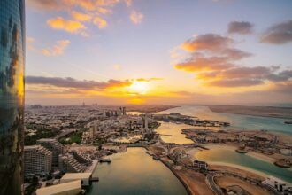 Dubai & Abu Dhabi: Liburan Premium dengan Sentuhan Spiritual 12 the sun is setting over a city and a body of water